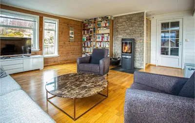 a living room with a table and chairs and a fireplace at Cozy Home In Bruvik With Wifi in Bruvik