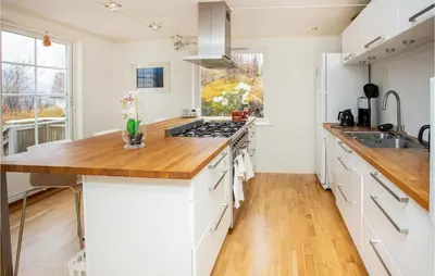 a kitchen with white cabinets and a wooden counter top at Cozy Home In Bruvik With Wifi in Bruvik
