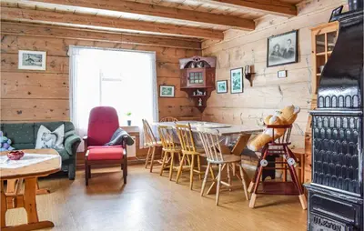 a dining room with wooden walls and a table and chairs at Pet Friendly Home In Evanger in Evanger