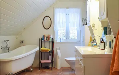 a bathroom with a tub and a toilet and a sink at Gorgeous Home In Fjell With Wifi in Lokøy