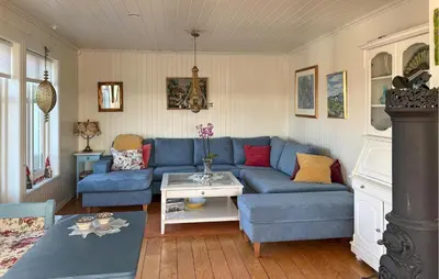 a living room with a blue couch and a table at Gorgeous Home In Fjell With Wifi in Lokøy