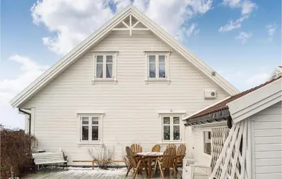 a white house with a table and chairs at Gorgeous Home In Fjell With Wifi in Lokøy