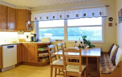 a kitchen and dining room with a table and a window at 5 Bedroom Beach Front Home In Lavik in Lavik