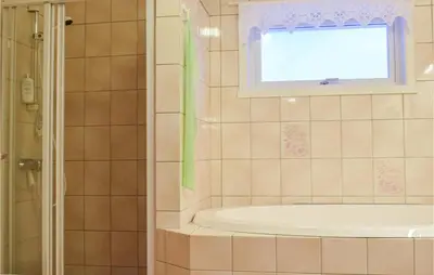 a bathroom with a tub and a window at 5 Bedroom Beach Front Home In Lavik in Lavik