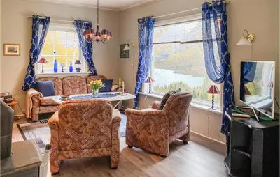 a living room with chairs and a table and a tv at Nice Home In Byrkjelo With Kitchen in Byrkjelobrua