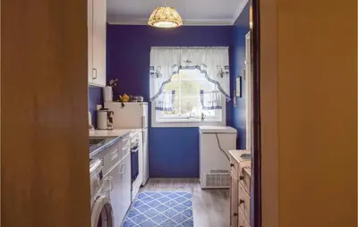 a kitchen with blue walls and a window at Nice Home In Byrkjelo With Kitchen in Byrkjelobrua