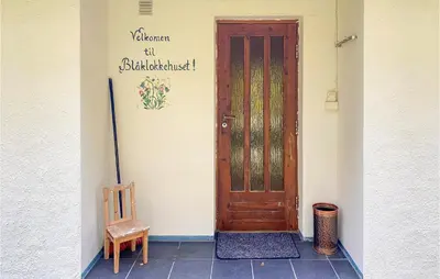 a door to a building with a chair next to it at Nice Home In Byrkjelo With Kitchen in Byrkjelobrua