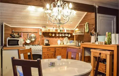 a kitchen with a table and a chandelier at 3 Bedroom Beautiful Home In Eikefjord in Eikefjord
