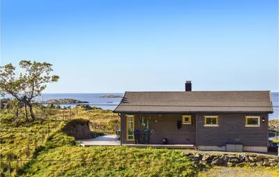 a small house on a hill next to the ocean at Valvik in Tansøy