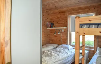 a bedroom with a bunk bed in a log cabin at Valvik in Tansøy