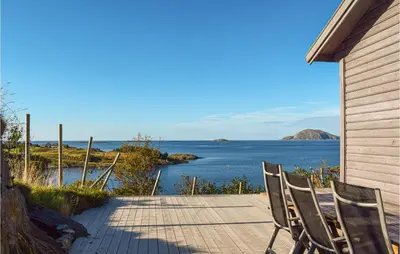 two chairs sitting on a patio looking out at the water at Valvik in Tansøy