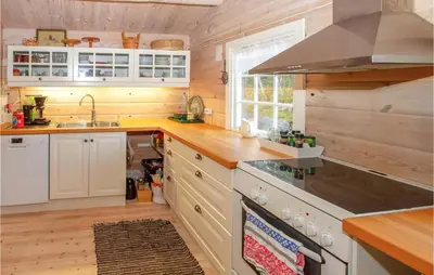a kitchen with white cabinets and a stove top oven at Cozy Home In Sykkylven With Kitchen in Sykkylven