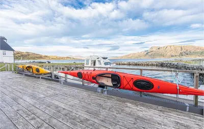 a group of boats sitting on a dock at Beach Front Home In Kvamsøy in Sandvik