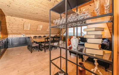 a dining room with a book shelf with books at Beach Front Home In Kvamsøy in Sandvik