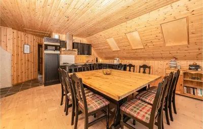 a kitchen and dining room with a wooden table and chairs at Beach Front Home In Kvamsøy in Sandvik