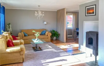 a living room with a couch and a fireplace at Lovely Apartment In Ellingsøy in Myklebost