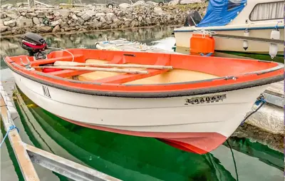 a small boat tied to a dock in the water at Lovely Apartment In Ellingsøy in Myklebost