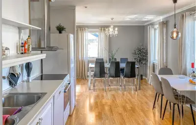 a kitchen and dining room with a table and chairs at Lovely Apartment In Ellingsøy in Myklebost