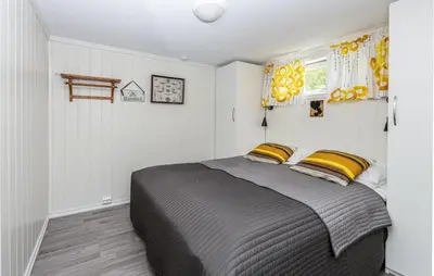 a bedroom with a large bed with yellow pillows at 2 Bedroom Awesome Home In Isfjorden in Isfjorden