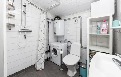 a bathroom with a toilet and a washing machine at 2 Bedroom Awesome Home In Isfjorden in Isfjorden
