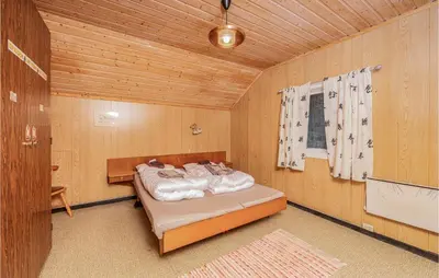 a bedroom with a bed in a wooden room at 5 Bedroom Pet Friendly Home In Vestnes in Vestnes