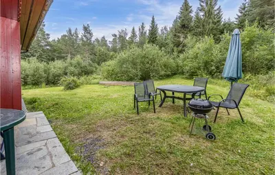 a patio with a table and chairs and an umbrella at 5 Bedroom Pet Friendly Home In Vestnes in Vestnes
