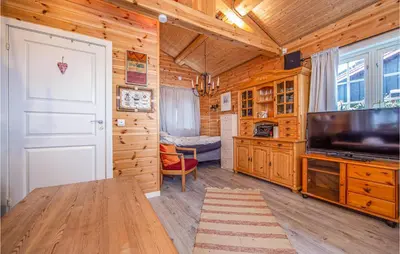 a living room with a large television and a bedroom at 2 Bedroom Cozy Home In Øydegard in Nastad