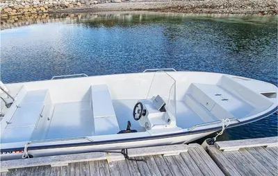 a white boat parked at a dock in the water at 3 Bedroom Beautiful Home In Øydegard in Aspa