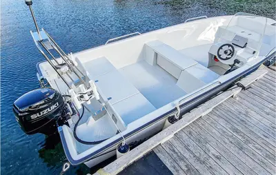 a white boat tied to a dock on the water at 3 Bedroom Beautiful Home In Øydegard in Aspa