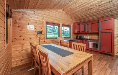 a kitchen with a wooden table in a cabin at 3 Bedroom Beautiful Home In Øydegard in Aspa