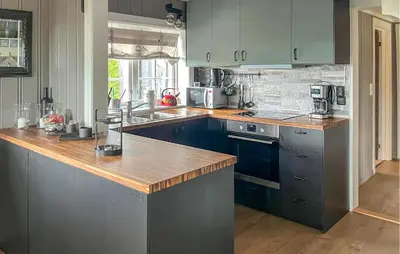 a kitchen with blue cabinets and a wooden counter top at Pet Friendly Home In Rena With Wifi in Rena