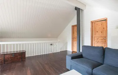 a living room with a blue couch and a door at Gorgeous Home In Søre Osen With Wifi in Midskogberget