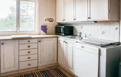 a kitchen with white cabinets and a sink and a microwave at Amazing Home In Tufsingdalen With Wifi in Bakken