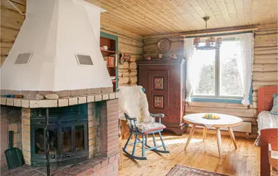 a living room with a fireplace and a table at Amazing Home In Tufsingdalen With Wifi in Bakken