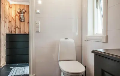 a small bathroom with a toilet and a window at Beautiful Home In Engerdal With Kitchen in Kvisla