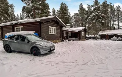 a car parked in the snow in front of a cabin at Lovely Home In Drevsjø With Lake View in Drevsjø