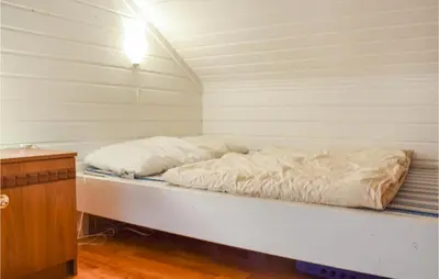 a bed in a room with white sheets on it at Awesome Home In Nord-Torpa With Kitchen in Nord Torpa