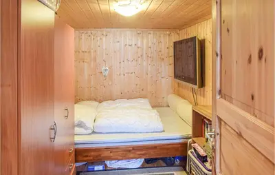 a small bedroom with a bed and a tv at Awesome Home In Nord-Torpa With Kitchen in Nord Torpa