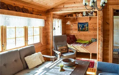 a living room of a log cabin with a table and chairs at 4 Bedroom Stunning Home In Vinstra in Vinstra