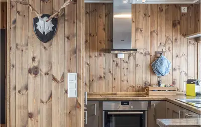 a kitchen with wood paneled walls and a counter at 4 Bedroom Lovely Home In Øyer in Øyer