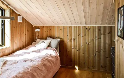 a bedroom with a bed in a wooden wall at 4 Bedroom Beautiful Home In Øyer in Øyer