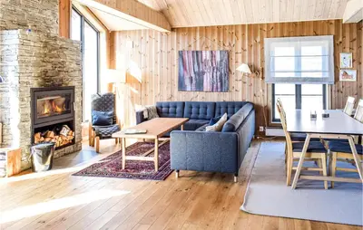 a living room with a couch and a table and a fireplace at 4 Bedroom Beautiful Home In Øyer in Øyer