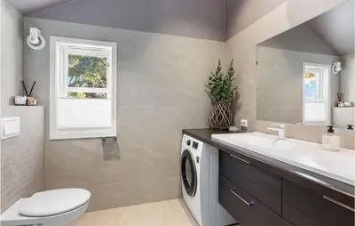 a bathroom with a washing machine and a sink at Gorgeous Home In Øyer With Sauna in Øyer