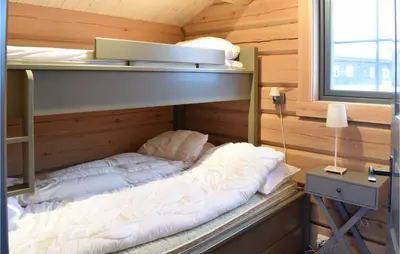 a bunk bed in a cabin with a window at Beautiful Home In Øyer With Sauna in Øyer