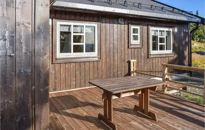 a wooden deck with a bench and a building at Stunning Home In Øyer With Wifi in Øyer