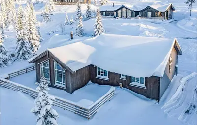 a cabin in the snow with snow covered trees at Stunning Home In Øyer With Wifi in Øyer