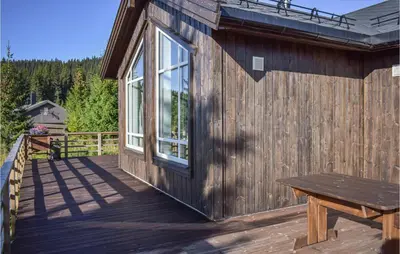 a wooden deck with a bench on the side of a cabin at Stunning Home In Øyer With Wifi in Øyer