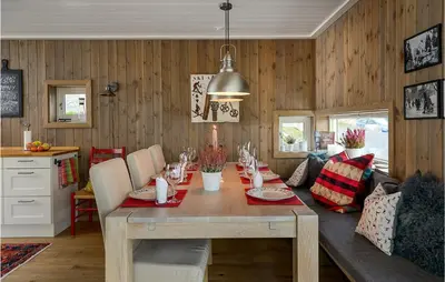 a dining room with a table and a couch at Gorgeous Home In Sjusjøen With Kitchen in Sjusjøen