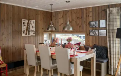a dining room with a wooden table and chairs at Gorgeous Home In Sjusjøen With Kitchen in Sjusjøen