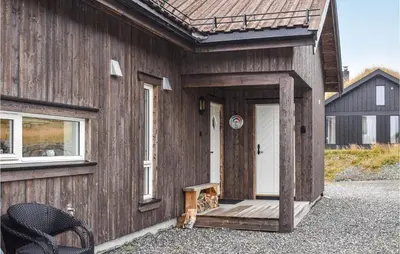 a cat sitting on the porch of a wooden house at 4 Bedroom Stunning Home In Øyer in Øyer